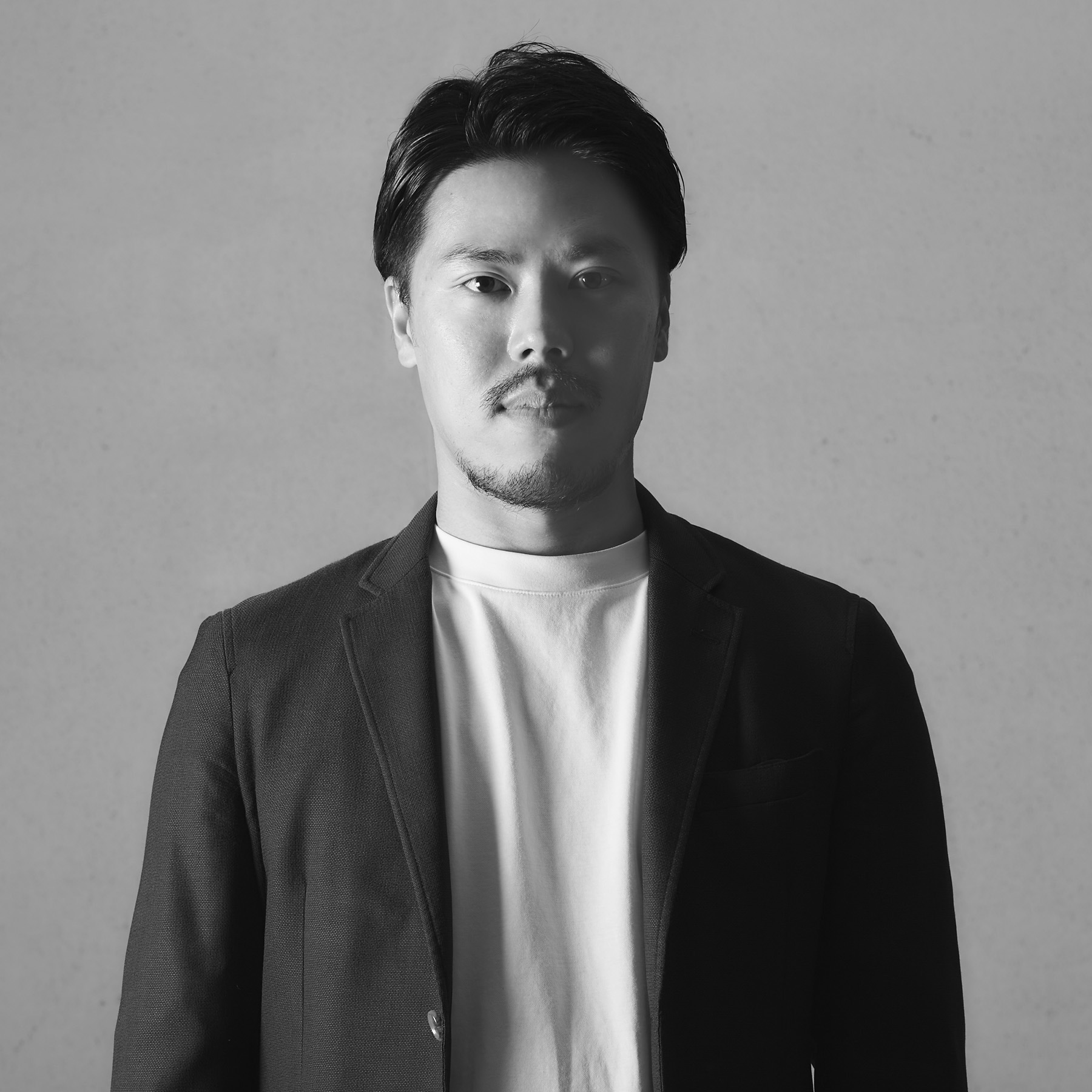 水本 穣戸（Shigeto Mizumoto）のポートレート — モノクロ、ジャケット＋白T、正面